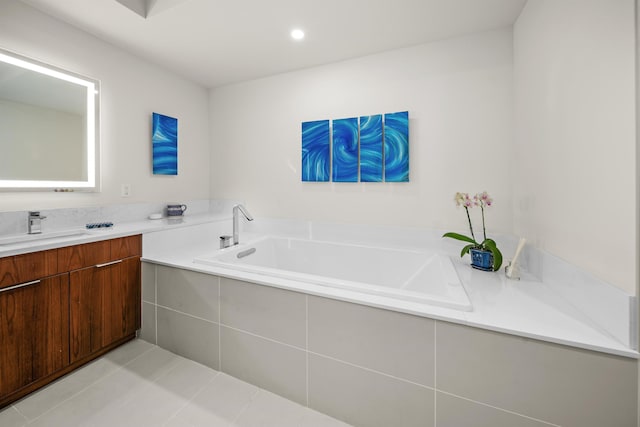 bathroom featuring vanity, a relaxing tiled tub, and tile patterned floors