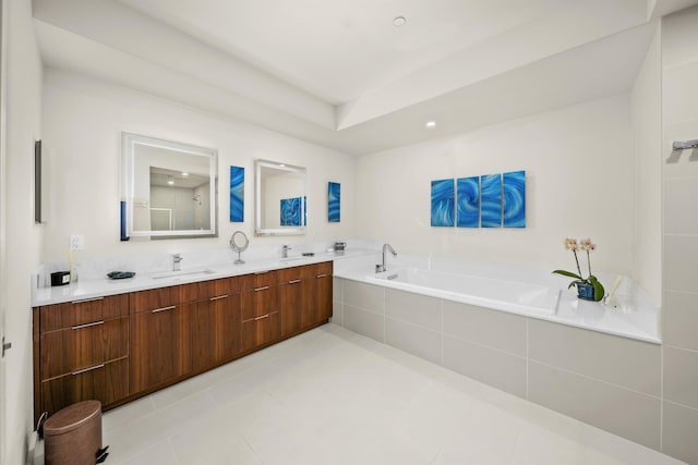 bathroom with tile patterned flooring, vanity, and tiled bath