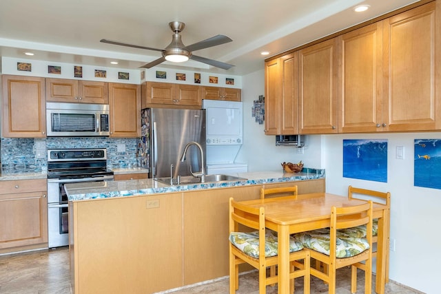 kitchen featuring stacked washer / drying machine, sink, appliances with stainless steel finishes, light stone countertops, and backsplash