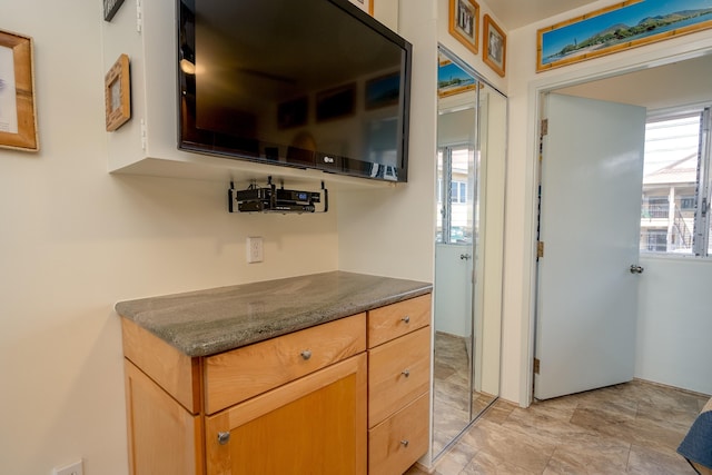 kitchen featuring a healthy amount of sunlight and dark stone counters