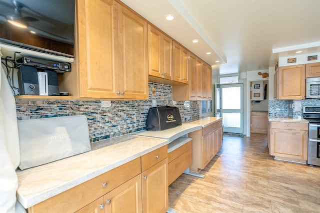 kitchen with light stone countertops, decorative backsplash, and stainless steel appliances