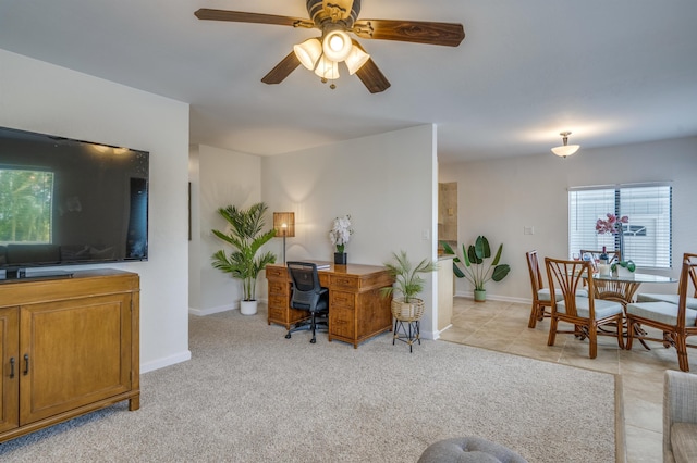 living room with light tile patterned floors, baseboards, a ceiling fan, and light colored carpet