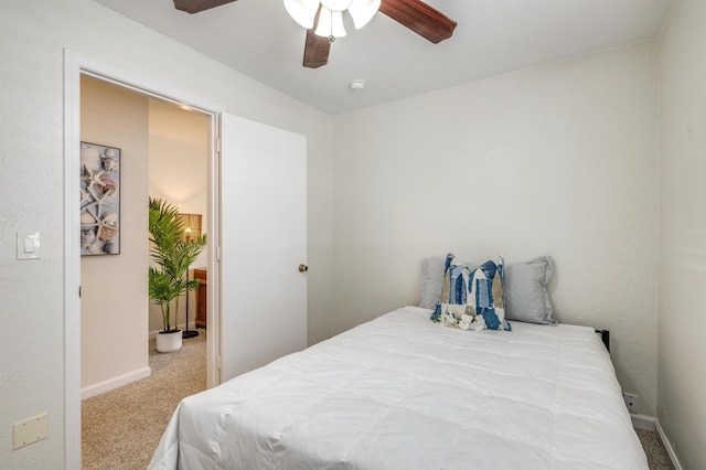 carpeted bedroom with ceiling fan and baseboards