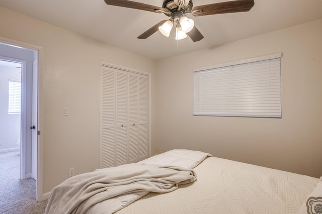 carpeted bedroom featuring a closet, ceiling fan, and baseboards