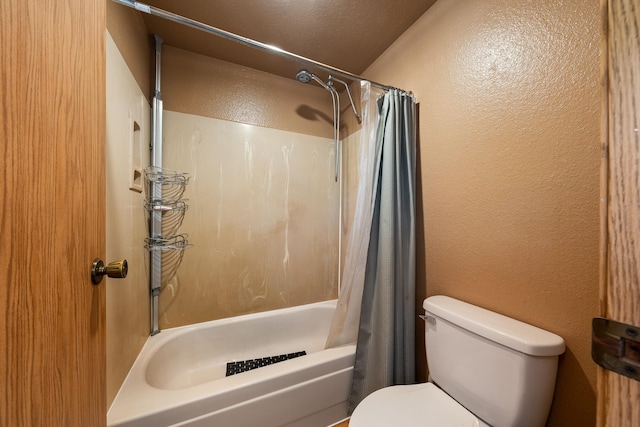 bathroom featuring a textured ceiling, shower / bath combo, and toilet