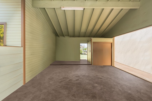 interior space with plenty of natural light, concrete flooring, and lofted ceiling with beams