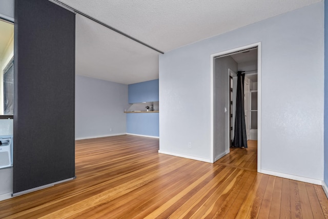 spare room with a textured ceiling and hardwood / wood-style flooring