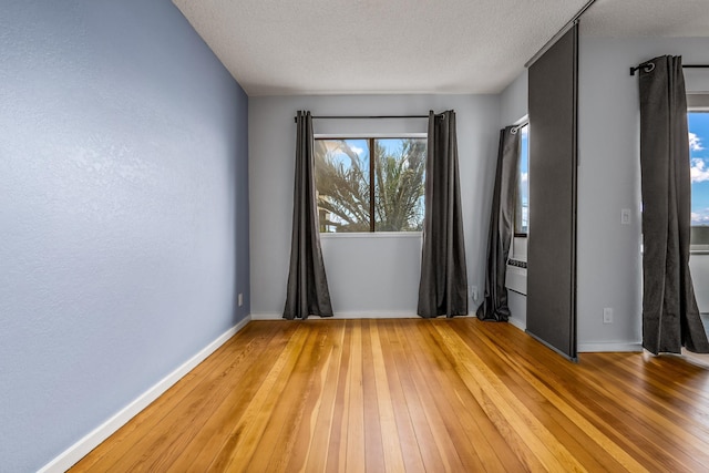 empty room featuring wood-type flooring and a textured ceiling