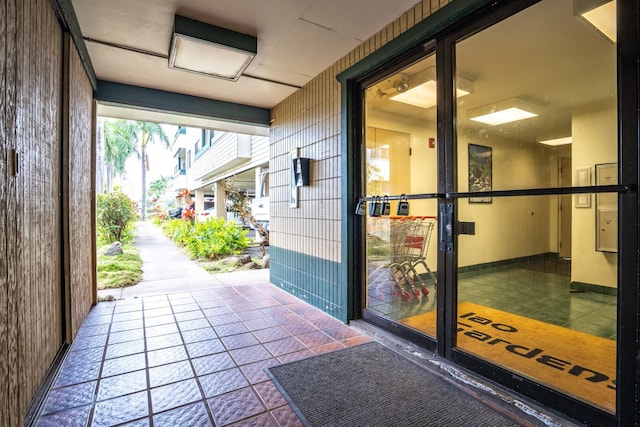 exterior space featuring wooden walls and tile patterned flooring