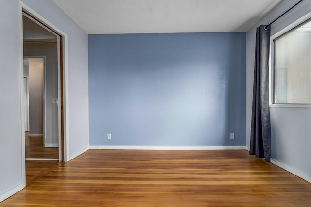 empty room featuring a textured ceiling and hardwood / wood-style flooring