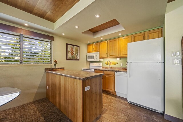 kitchen featuring sink, a raised ceiling, tile patterned floors, kitchen peninsula, and white appliances