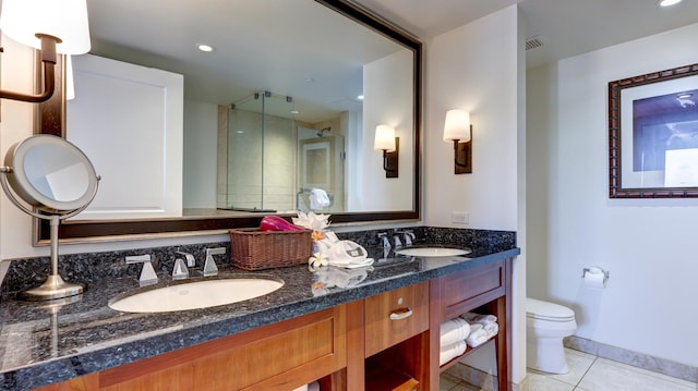 bathroom featuring toilet, walk in shower, tile patterned floors, and vanity