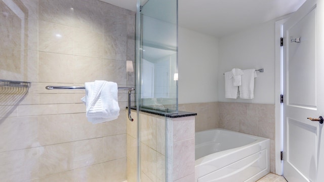 bathroom featuring shower with separate bathtub