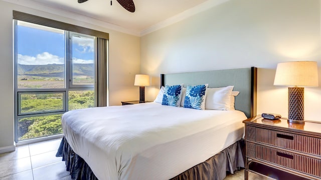 tiled bedroom featuring ceiling fan, a mountain view, and crown molding