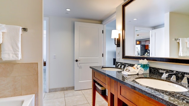 bathroom featuring tile patterned floors, vanity, and a tub to relax in