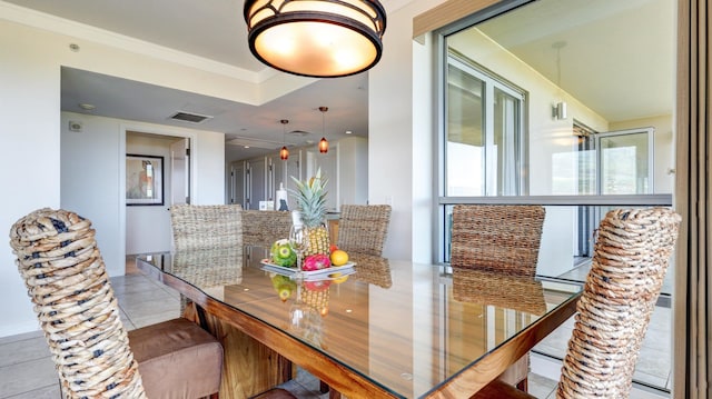 dining room with light tile patterned floors and crown molding