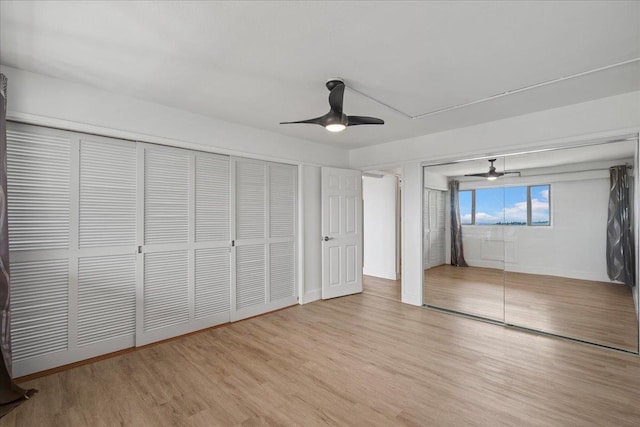 2158 Main St Unit 704, Wailuku, HI 96793 - unfurnished bedroom featuring wood finished floors, ceiling fan, and two closets