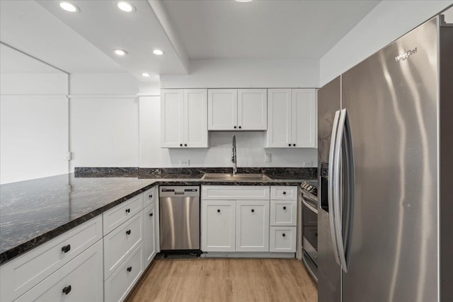 2158 Main St Unit 704, Wailuku, HI 96793 - kitchen featuring appliances with stainless steel finishes, light wood-type flooring, recessed lighting, white cabinets, and dark stone countertops