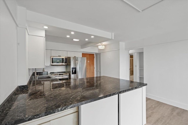 2158 Main St Unit 704, Wailuku, HI 96793 - kitchen with stainless steel appliances, recessed lighting, a peninsula, white cabinetry, and dark stone countertops