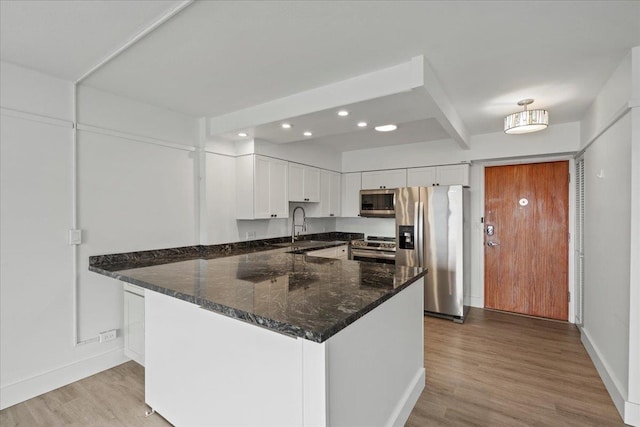 2158 Main St Unit 704, Wailuku, HI 96793 - kitchen featuring stainless steel appliances, light wood-style flooring, white cabinets, dark stone countertops, and recessed lighting