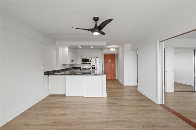 2158 Main St Unit 704, Wailuku, HI 96793 - kitchen featuring appliances with stainless steel finishes, ceiling fan, a peninsula, and light wood-style floors