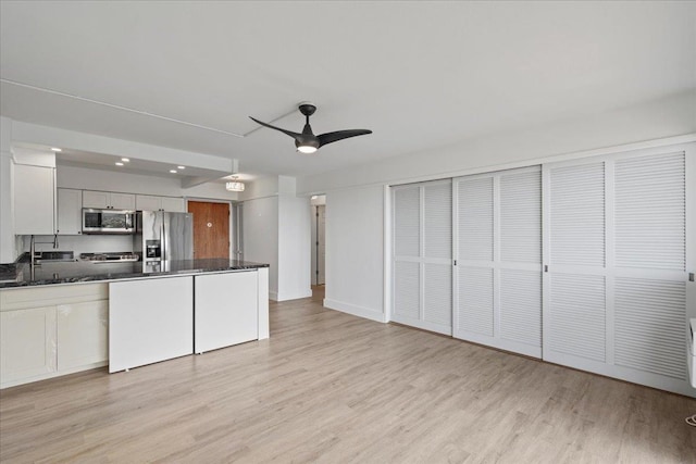 2158 Main St Unit 704, Wailuku, HI 96793 - kitchen with appliances with stainless steel finishes, a ceiling fan, light wood-style flooring, a peninsula, and white cabinets
