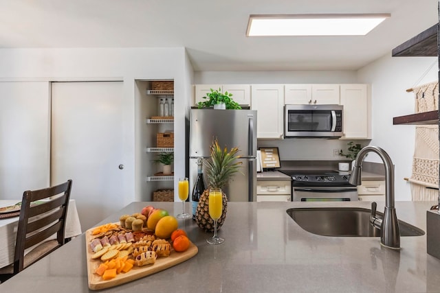 480 Kenolio Rd Unit 13-101, Kihei, HI 96753 - kitchen with appliances with stainless steel finishes, a sink, white cabinetry, and dark countertops