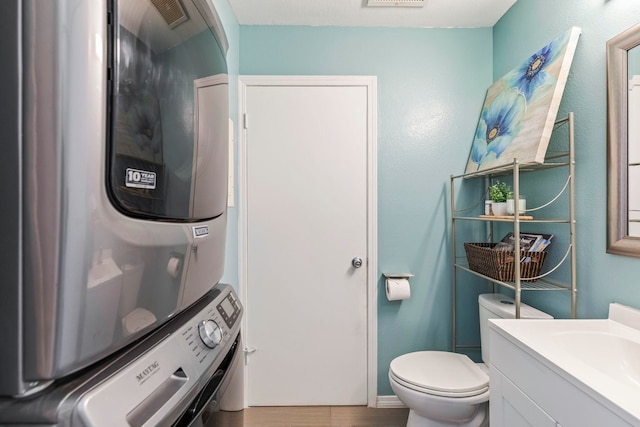 480 Kenolio Rd Unit 13-101, Kihei, HI 96753 - bathroom with estacked washer and dryer, vanity, toilet, and wood finished floors