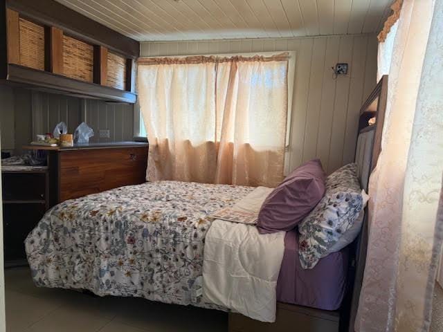 bedroom with multiple windows, tile patterned floors, and wood ceiling