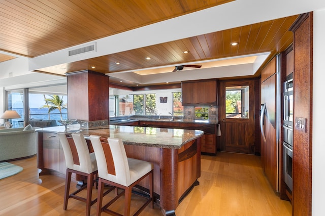 4000 Wailea Alanui Dr Unit 502, Kihei, HI 96753 - kitchen featuring light wood finished floors, wood ceiling, a peninsula, a sink, and a breakfast bar