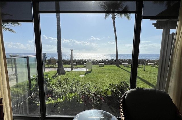 sunroom featuring a water view