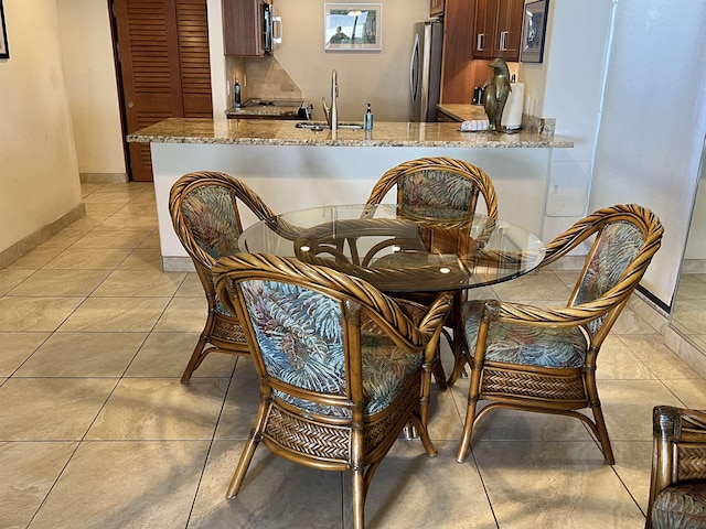 dining room featuring light tile patterned floors and baseboards
