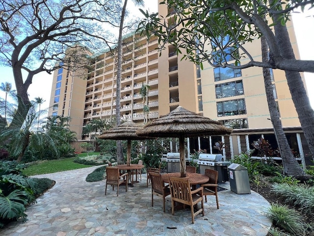 view of patio / terrace featuring outdoor dining area, an outdoor kitchen, a gazebo, and grilling area