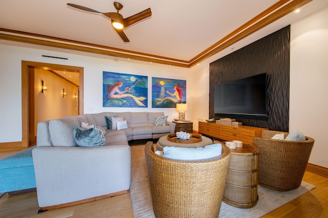 living room with hardwood / wood-style flooring, ceiling fan, and ornamental molding