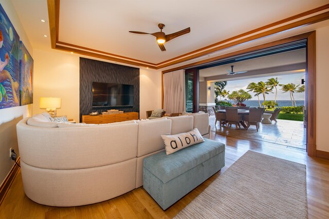 living room featuring ceiling fan, crown molding, and wood-type flooring