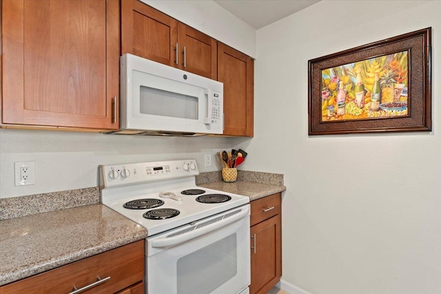 kitchen with light stone counters and white appliances