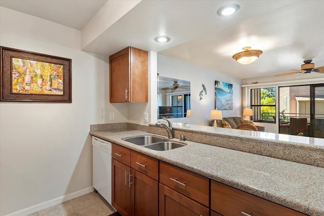 kitchen featuring ceiling fan, dishwasher, sink, light stone counters, and light tile patterned floors