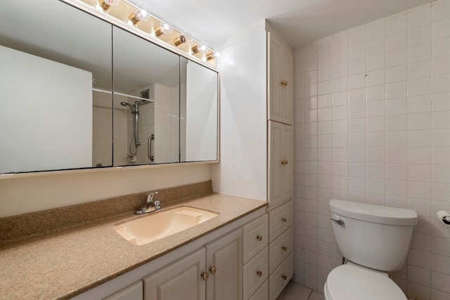 full bathroom featuring toilet, vanity, and tile walls