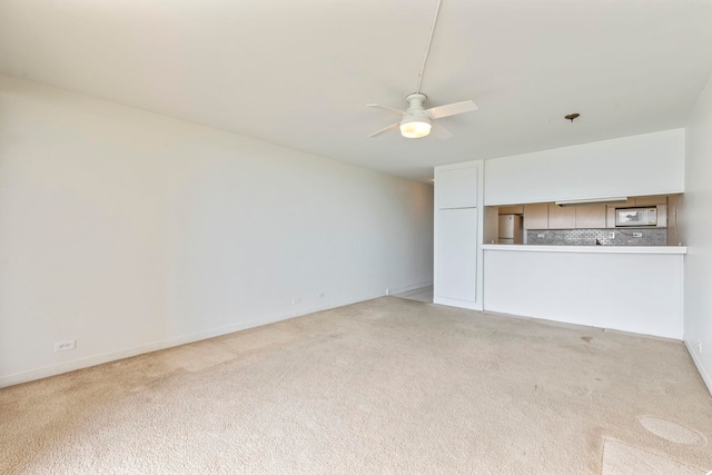 unfurnished living room with light carpet and a ceiling fan