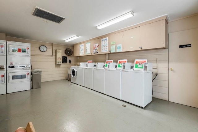 community laundry room featuring washing machine and dryer, visible vents, and stacked washer / drying machine