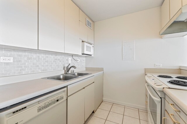 kitchen featuring white appliances, tasteful backsplash, light countertops, and a sink