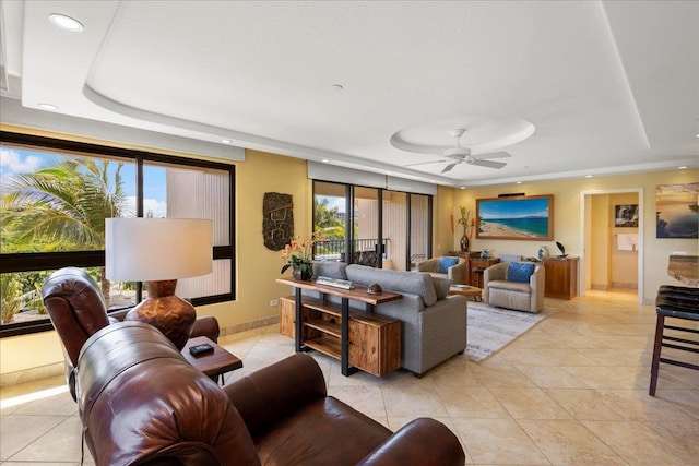 tiled living room featuring a tray ceiling, a wealth of natural light, and ceiling fan