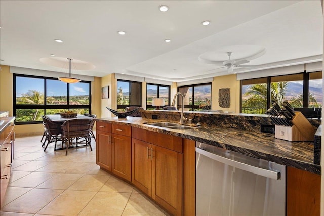 kitchen with ceiling fan, sink, stainless steel dishwasher, dark stone counters, and light tile patterned floors