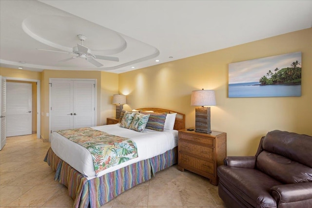 tiled bedroom featuring a tray ceiling and ceiling fan