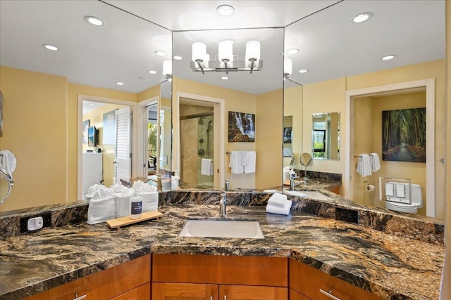 bathroom featuring vanity, toilet, walk in shower, and a chandelier