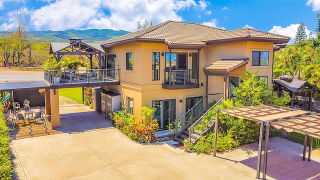 view of front of home with a gazebo, a mountain view, a balcony, and a patio