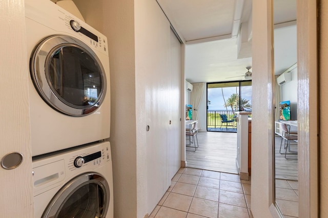laundry area featuring stacked washer and dryer, a ceiling fan, laundry area, and light tile patterned flooring