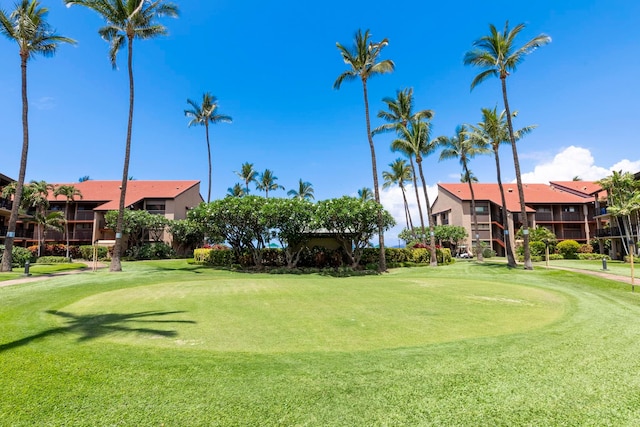 view of home's community with a yard and view of golf course