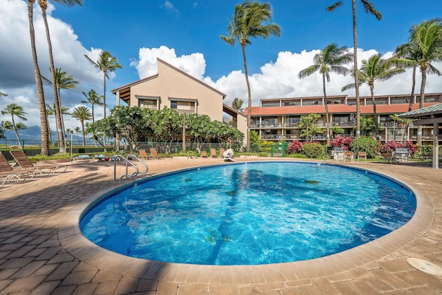 community pool with fence and a patio