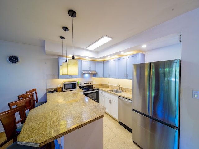 kitchen with pendant lighting, sink, decorative backsplash, appliances with stainless steel finishes, and kitchen peninsula